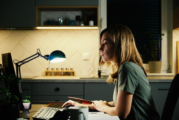 Tired woman works at home workplace