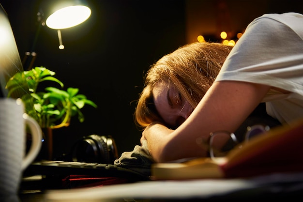 Tired woman works late at home workplace