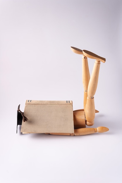 tired wooden student sleeps covered with book