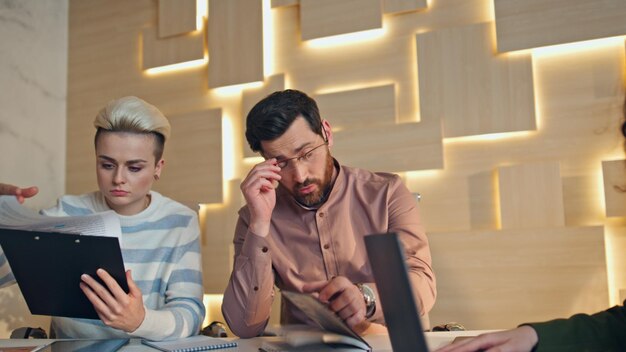 Photo tired workers sitting boardroom desk solving issues close up man bring coffee