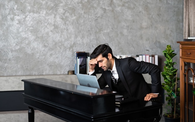 Photo tired and worried businessman at workplace in office holding his head on hands after late night work. depression concept.