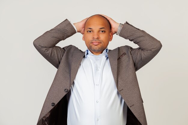 tired young businessman looking at the camera holding his hands behind his head, leaning back in a chair to rest a few minutes on a hard day in the office.