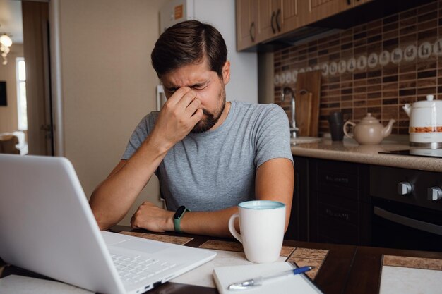 Tired young man feel pain eyestrain from computer work