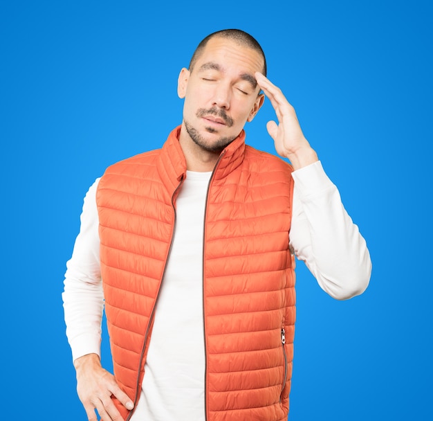 Tired young man posing against background