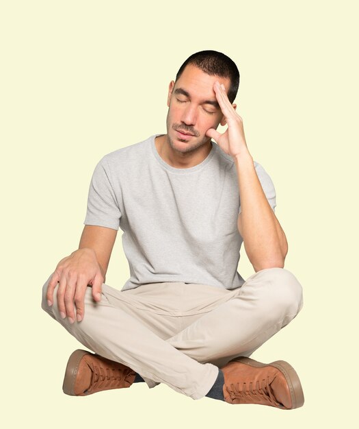 Tired young man posing against background