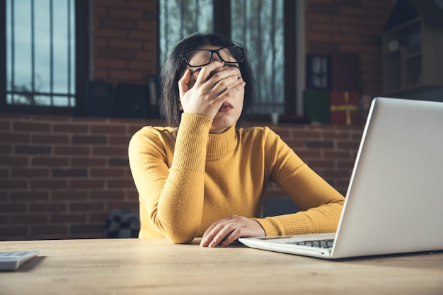 Tired young woman in office desk