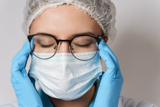 Tiredness or sickness. Young female doctor with a headache