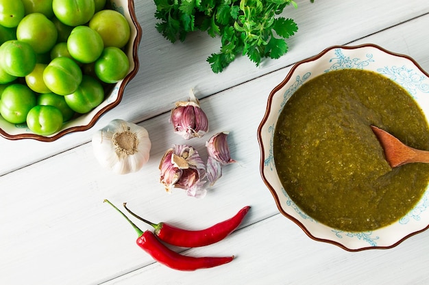 Ткемали соус традиционная грузинская кухня зеленая вишня слива на белом деревянном столе крупный план деревенская еда фон нет людей выборочный фокус