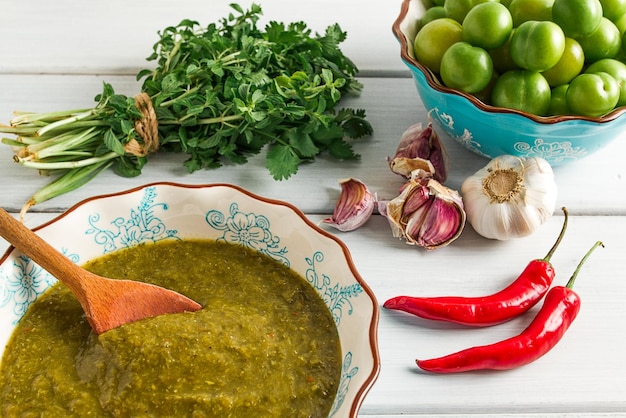 Salsa tkemali cucina georgiana tradizionale prugna verde ciliegia su un tavolo di legno bianco primo piano cibo rustico sfondo nessun fuoco selettivo delle persone