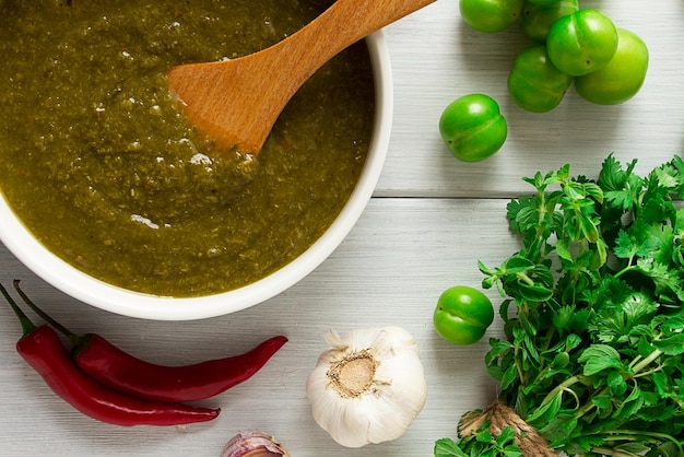 Foto tkemali saus traditionele georgische keuken groene kersenpruim op een witte houten tafel close-up rustieke voedsel achtergrond geen mensen selectieve focus