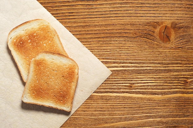 Toast bread roasted on wooden background, top view