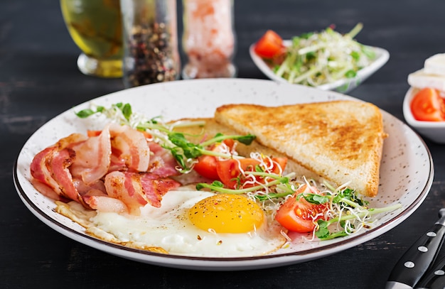 toast, egg, bacon and tomatoes and microgreens salad.