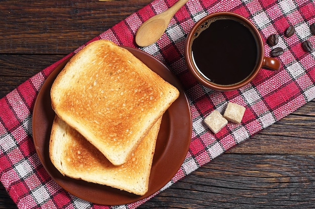 Toast en kop warme koffie op rood tafellaken. Bovenaanzicht