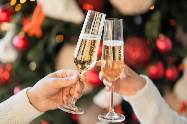 A toast to the holiday a couple of friends hold glasses with a champagne drink and clink