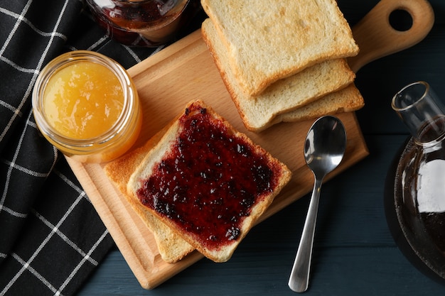 Toast, jam en thee op houten achtergrond, bovenaanzicht