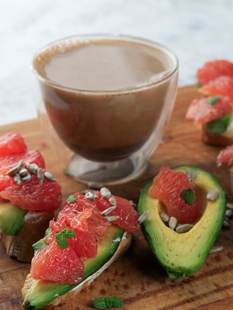 Toast met avocado, zachte kaas, grapefruit en een kopje koffie