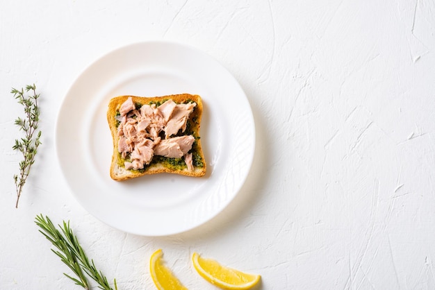 Toast met chimichurri saus en tonijn op een witte plaat Witte achtergrond Minimalistisch design Handige snack Plaats voor tekst