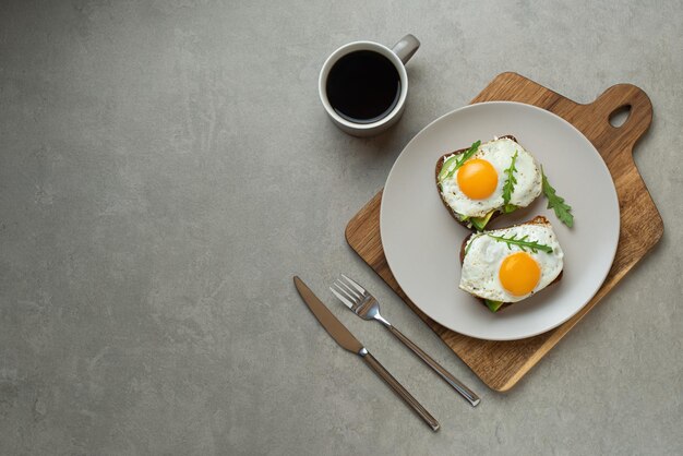 Toast met ei en avocado op een grijze achtergrond in een bord gezond ontbijt