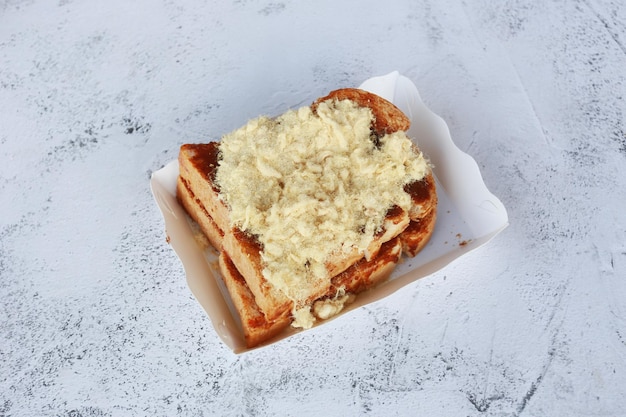 Toast met gedroogd versnipperd varkensvlees in papaer box op stenen achtergrond zelfgemaakte koken