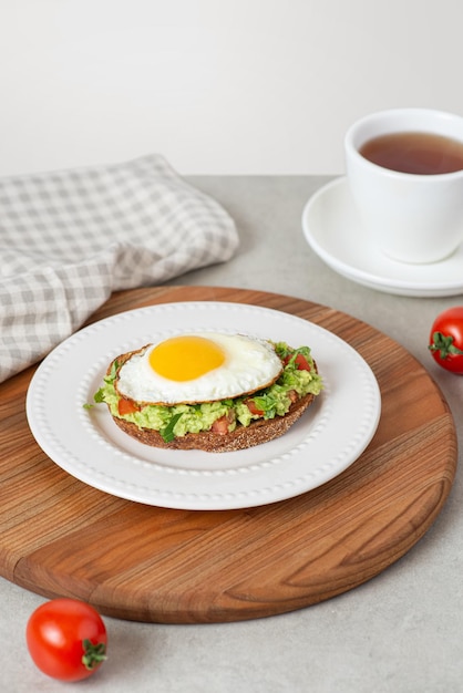 Toast met guacamole en avocado in een wit bord op tafel