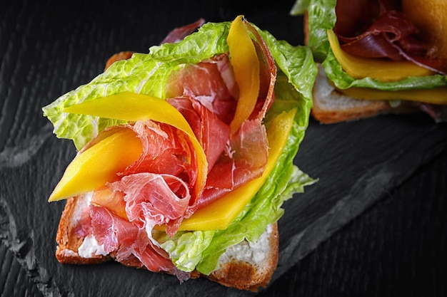 Toast met ham en kaas op zwarte leisteen