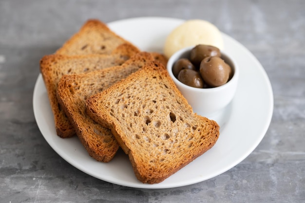 Toast met kaas en olijven op het bord