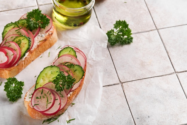 Toast met kaas en radijs Sandwiches met kwark radijs komkommer en groene uien op oude gebarsten tegel achtergrond Gezonde lente sandwiches Traditionele Scandinavische toast Bovenaanzicht