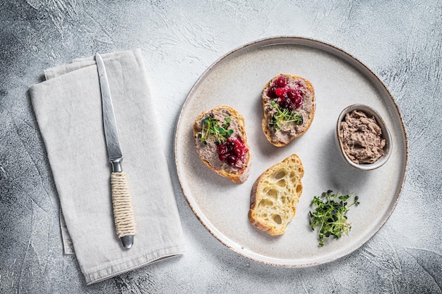 Toast met kip rillettes paté op wit brood met spruitjes. Witte achtergrond. Bovenaanzicht.