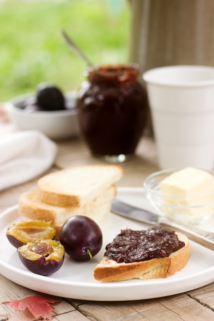 Toast met pruimenjam en jam. Ontbijt in de tuin. Rustieke stijl