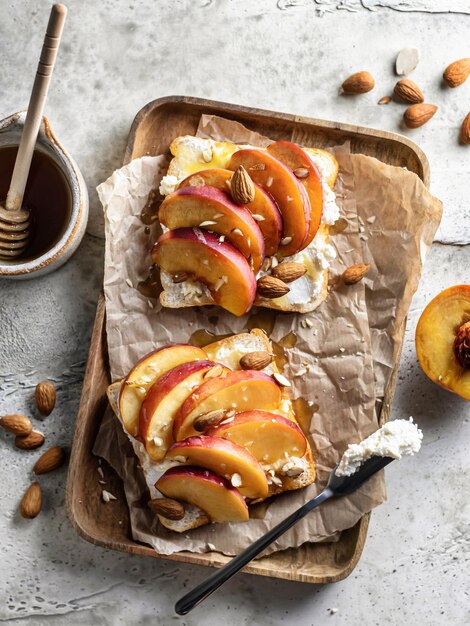 Toast met roomkaas verse sappige perzik amandel en honing Gezond zomers voorgerecht of tussendoortje