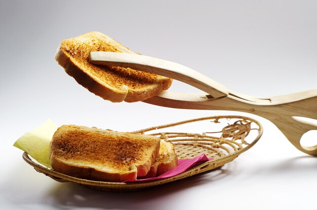 Toast op een bord en een houten tang