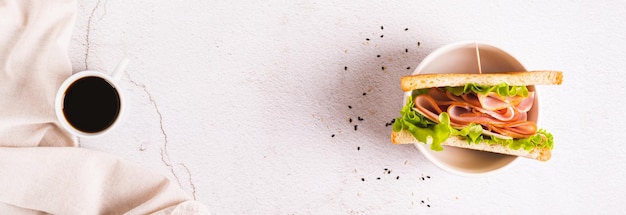 Toast sandwich with ham cheese and herbs in a bowl on the table top view web banner