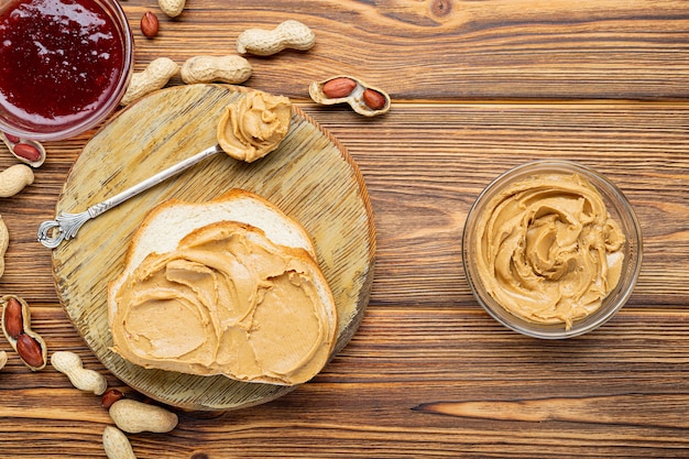 Toast sandwich with peanut butter spoon and jar of peanut butter