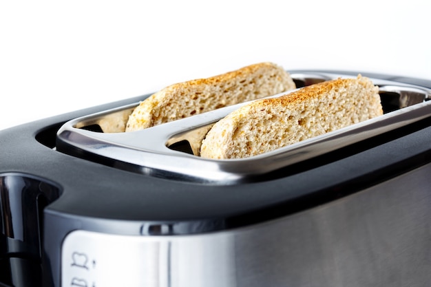 Toast in a toaster close-up on white