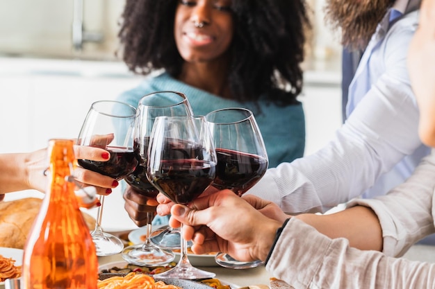 Toast tussen vrienden met glazen rode wijn