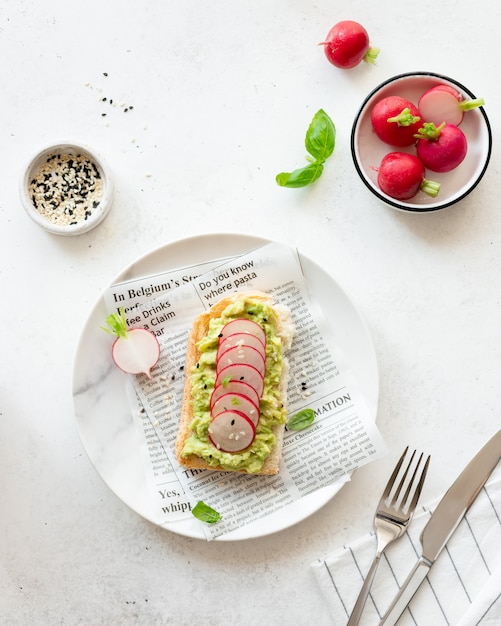 Toast with avocado, fresh radish, sesame and basil