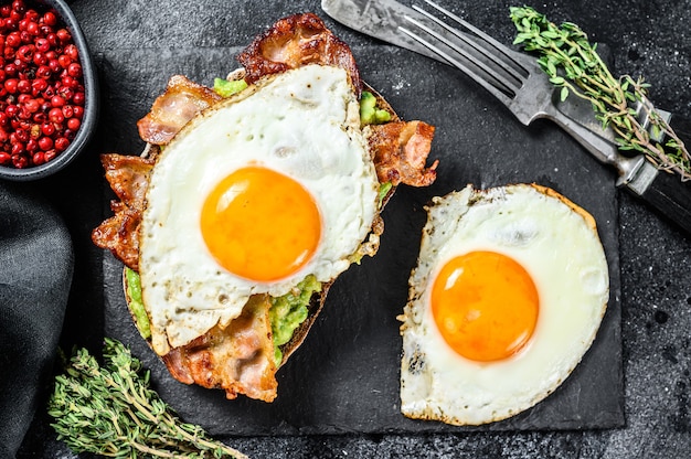 Toast with avocado, fried bacon, and egg