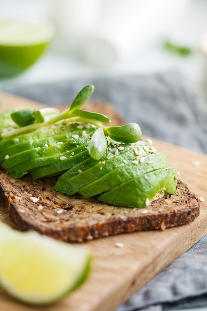 Toast with avocado on a wooden board on a breakfast table The concept of vegetarian and healthy diet food