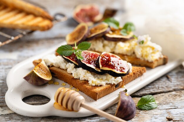 Photo toast with cottage cheese and figs drizzled with honey for breakfast