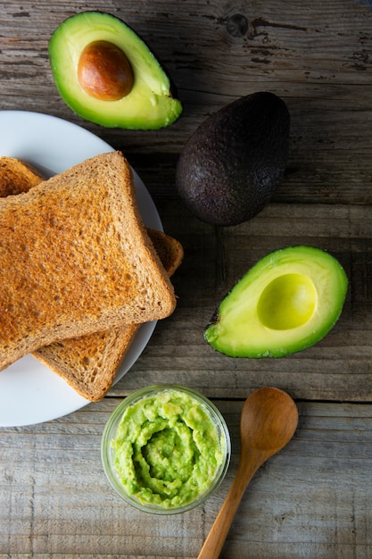 Toast with guacamole, avocado slices. Healthy food, snack. Breakfast. Wooden rustic table.