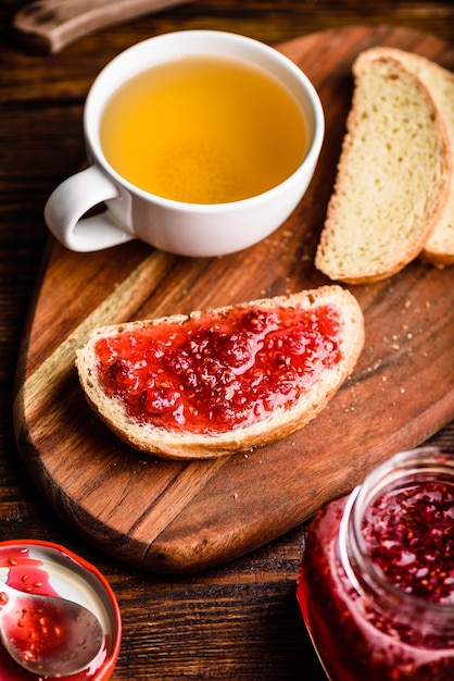 Toast con marmellata di lamponi fatta in casa con una tazza di tè verde