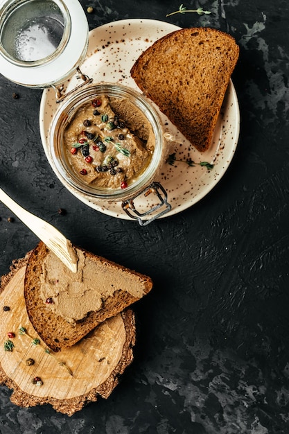 Toast con patè o mousse patè di fegato di pollo fatto in casa in un barattolo di vetro verticale immagine vista dall'alto posto per il testo