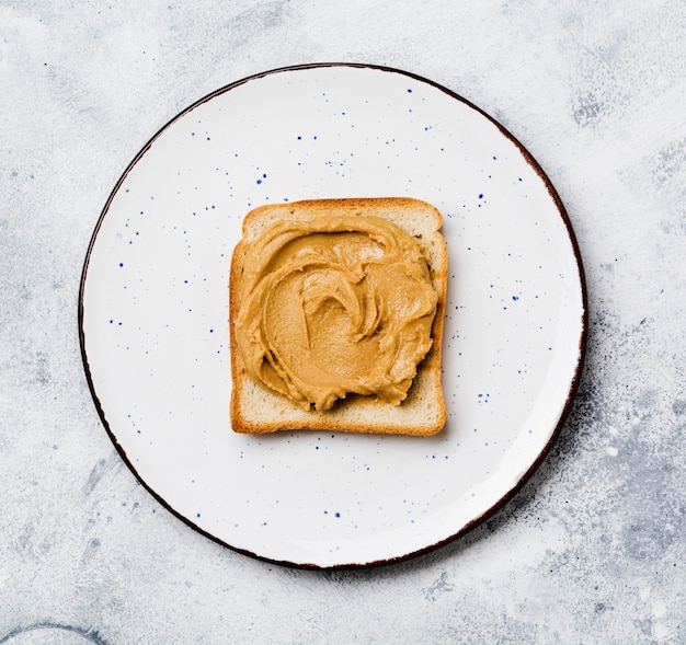 Toast with peanut butter and banana slices on an old gray concrete