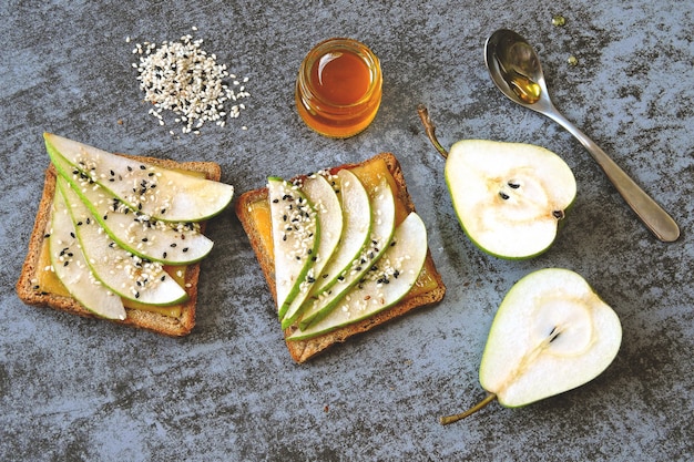 Toast with pear, cheese and honey. Healthy snack. Keto breakfast. Keto lunch. Vegetarian open sandwich with pear and cheese. Bruschetta with cheese, pear and honey.