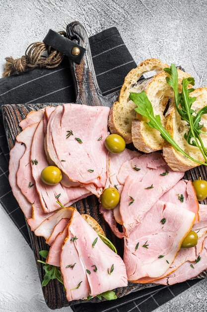 Photo toast with pork ham and olives. white background. top view. copy space.