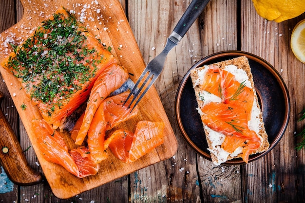 Pane tostato con salmone affumicato su tavola di legno