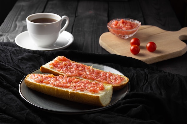 Toast with tomato, traditional spanish breakfast. olive oil,\
black background. pan tumaka