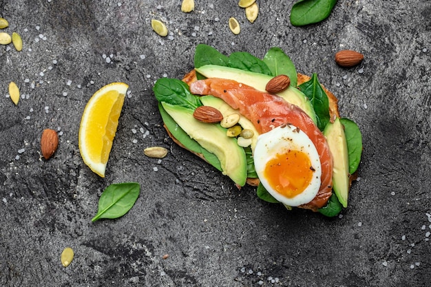 Toast zalm avocado kaas ei spinazie noten en koffie Gezonde vetten schoon eten om gewicht te verliezen Ketogeen dieet ontbijt Lange banner formaat bovenaanzicht