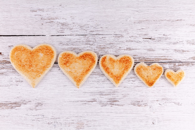 Foto cuoricini di pane tostato insieme in fila, sostegno nella grande famiglia