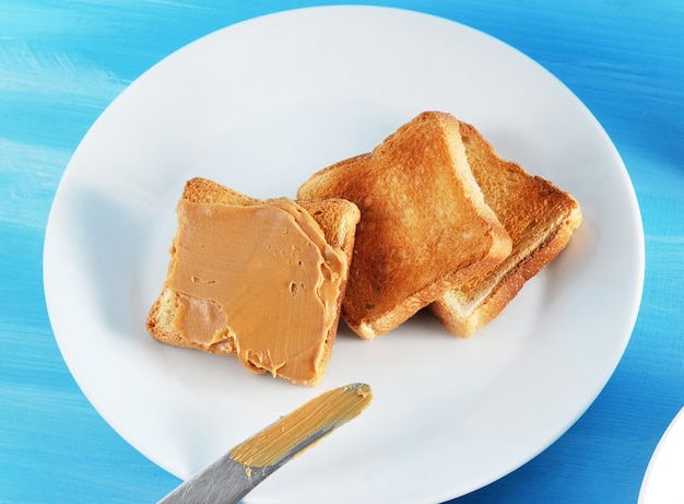 Pane tostato toast con burro di arachidi e un piatto